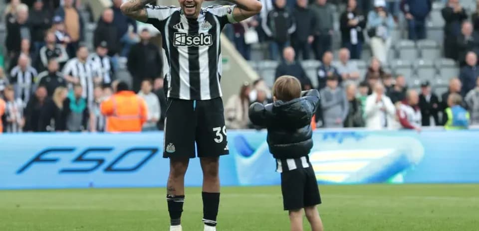Игрок Newcastle United празднует с ребенком на поле