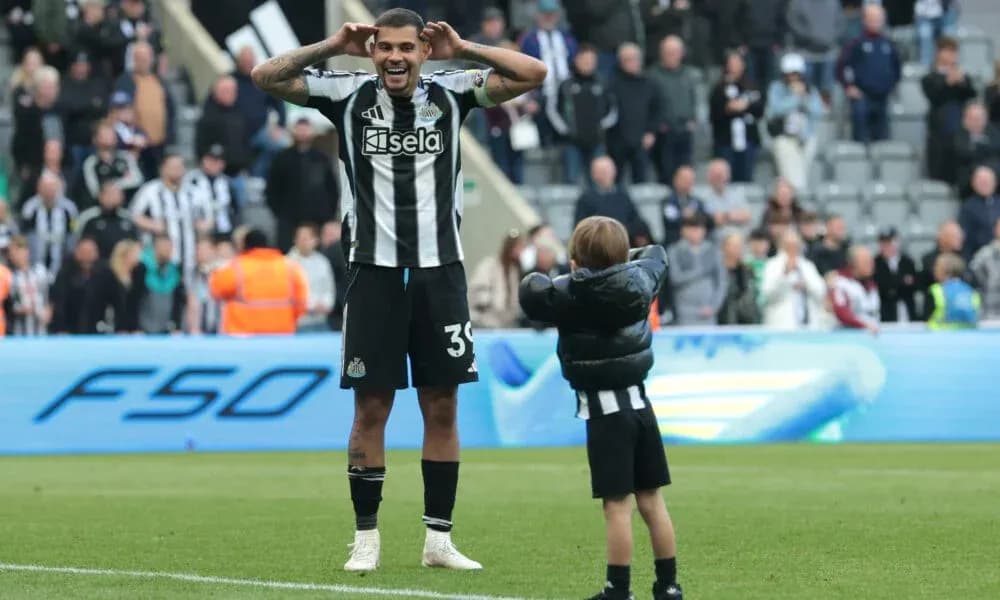 Игрок Newcastle United празднует с ребенком на поле