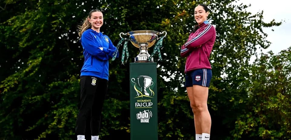 Две игрока стоят рядом с кубком FAI Women's Cup