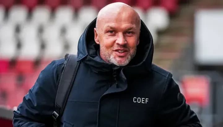 Человек в куртке с надписью COEF улыбается