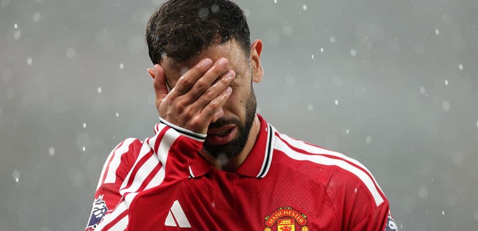 Игрок Manchester United прикрывает лицо рукой в дождь