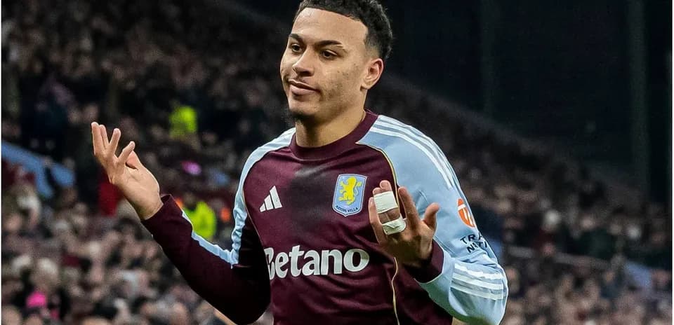Игрок Aston Villa с поднятыми руками на поле