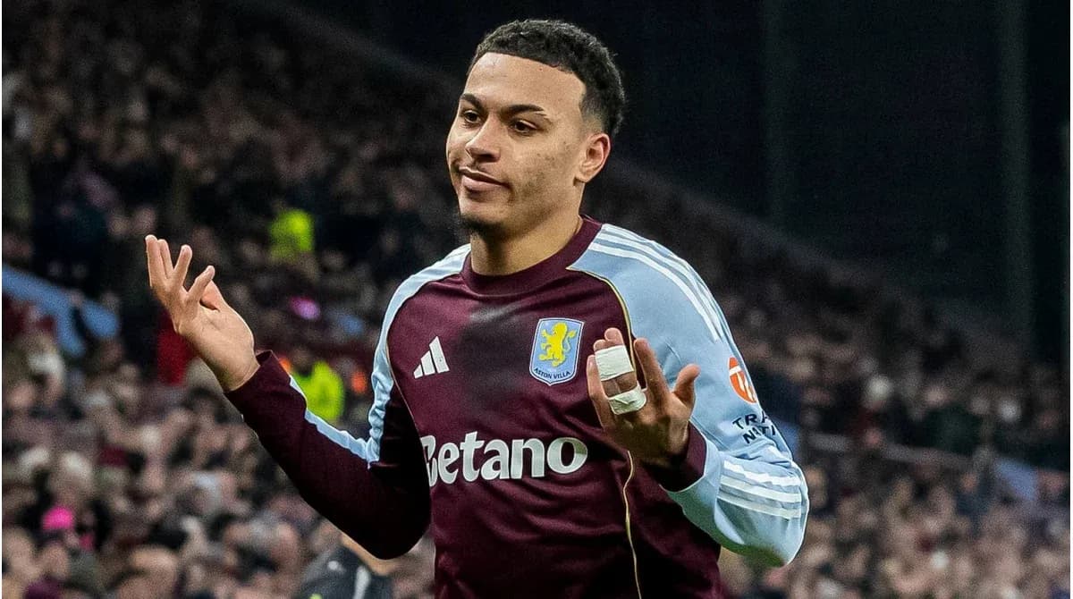 Игрок Aston Villa с поднятыми руками на поле