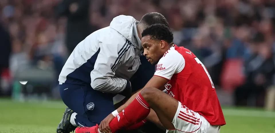 Игрок Arsenal сидит на поле с медицинским работником