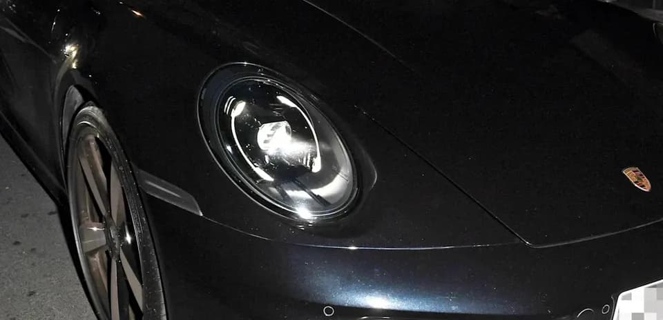 Два человека в спортивном автомобиле Porsche ночью