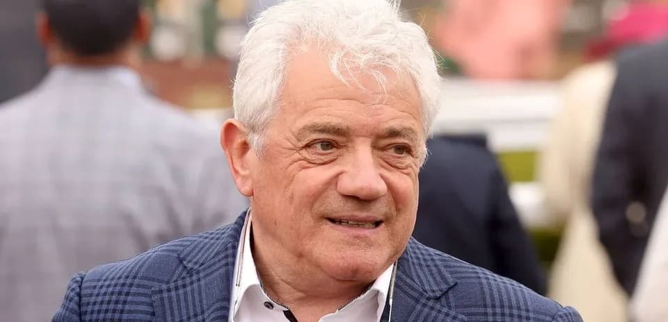 Человек с белыми волосами в клетчатом пиджаке
