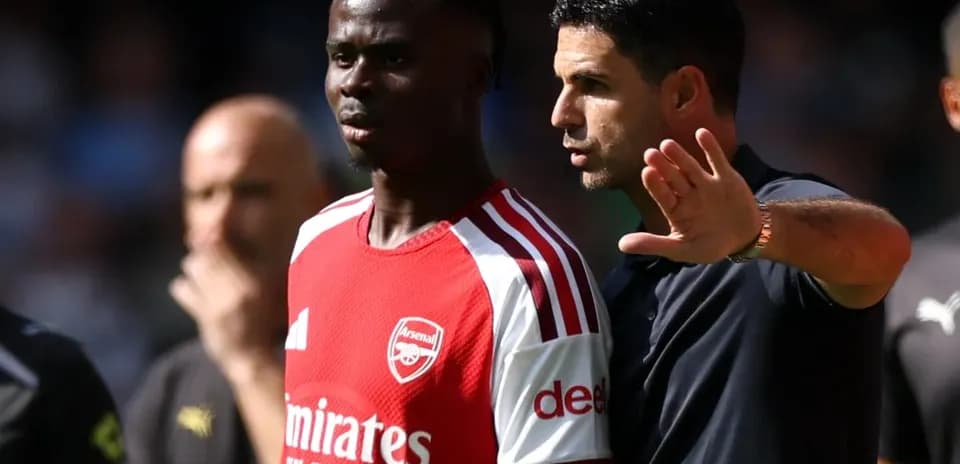 Тренер объясняет тактику игроку Arsenal на поле