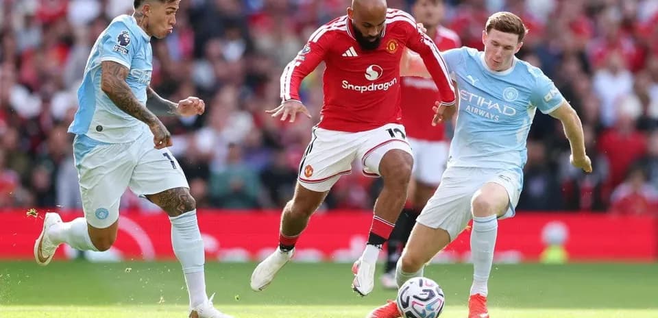 Игроки Manchester United и Manchester City борются за мяч