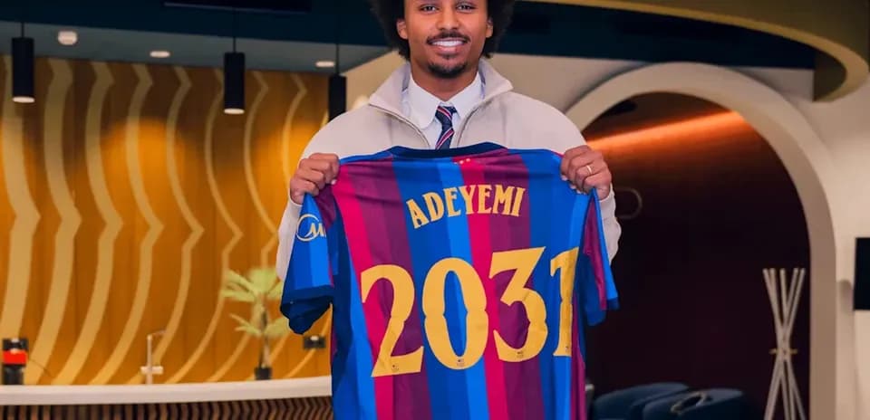 Игрок держит футболку с именем Адееми и номером 2031