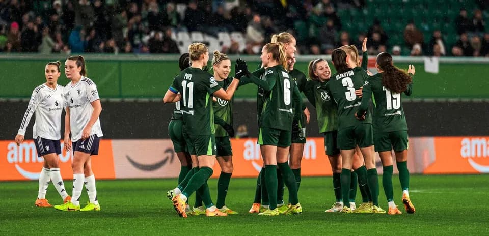 Игроки VfL Wolfsburg празднуют гол на поле