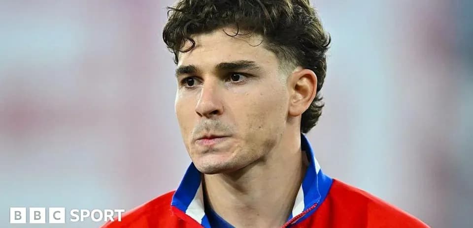 Игрок в красной форме на поле стадиона