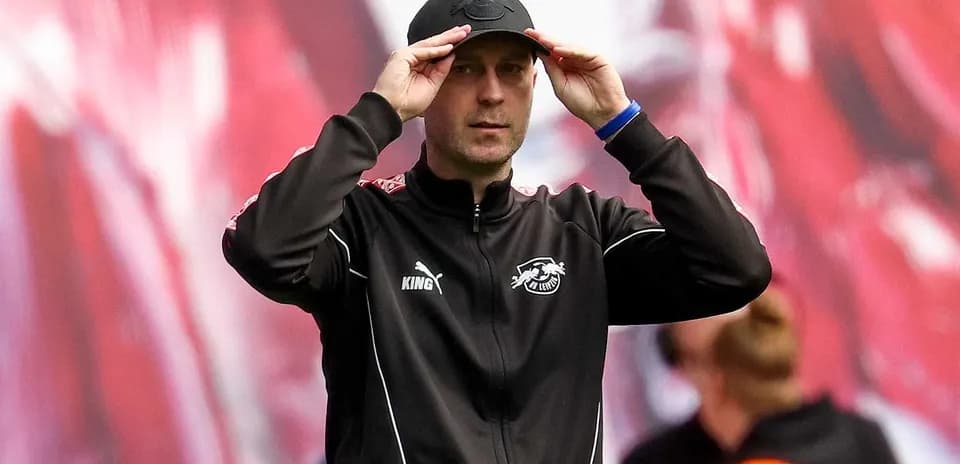 Тренер adjusts cap during match on the sideline