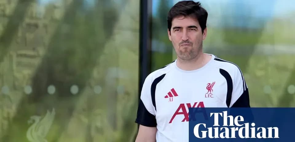 Человек в футболке Liverpool покидает тренировочный центр