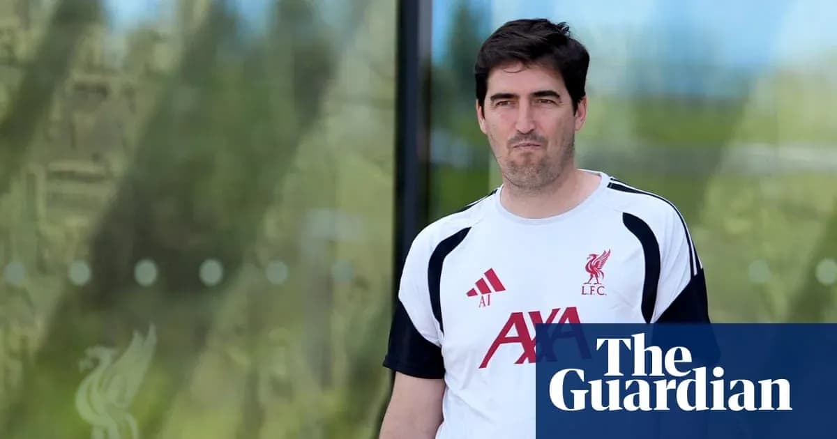 Человек в футболке Liverpool покидает тренировочный центр