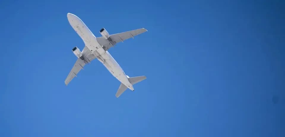 Самолет летит высоко в голубом небе