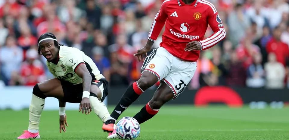 Игрок Manchester United с мячом, соперник на земле