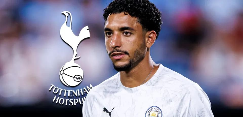 Игрок в футболке Manchester City на фоне логотипа Tottenham