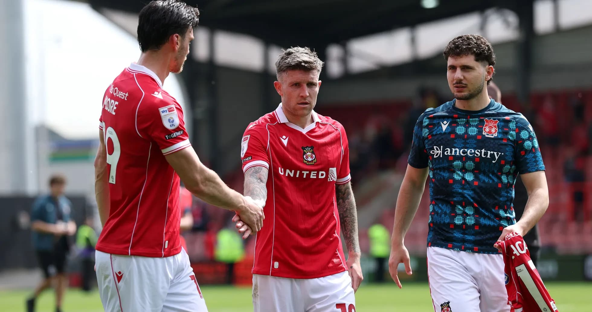 Игроки Wrexham United обмениваются рукопожатиями после матча