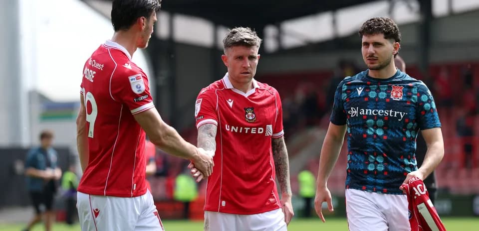 Игроки Wrexham United обмениваются рукопожатиями после матча