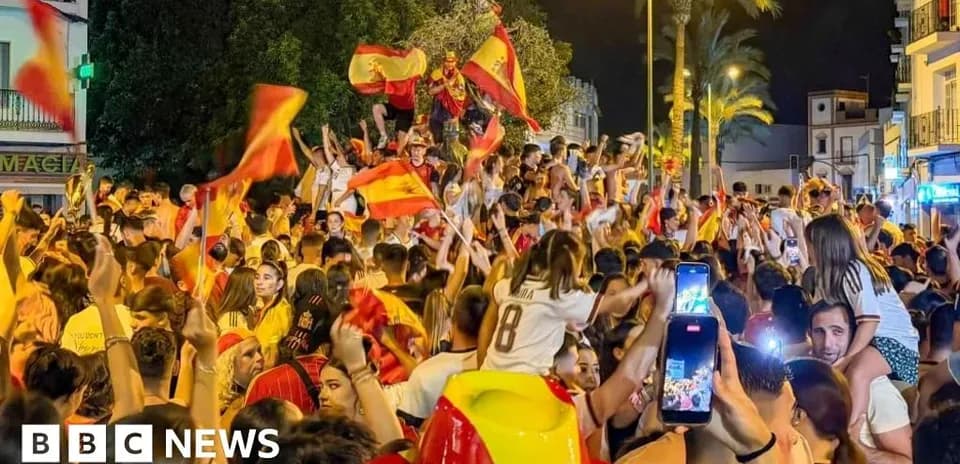 Толпа людей с флагами Испании на праздновании