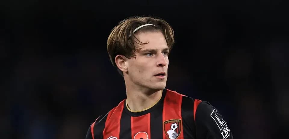 Игрок AFC Bournemouth в черно-красной форме на поле