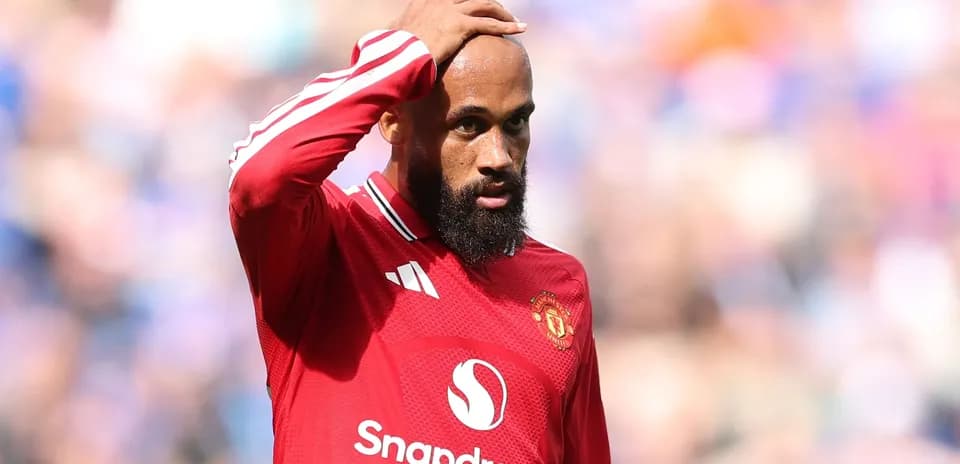 Игрок Manchester United с рукой на лбу во время матча