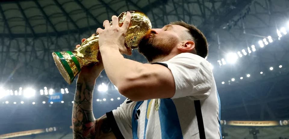 Игрок целует кубок чемпионата мира на стадионе
