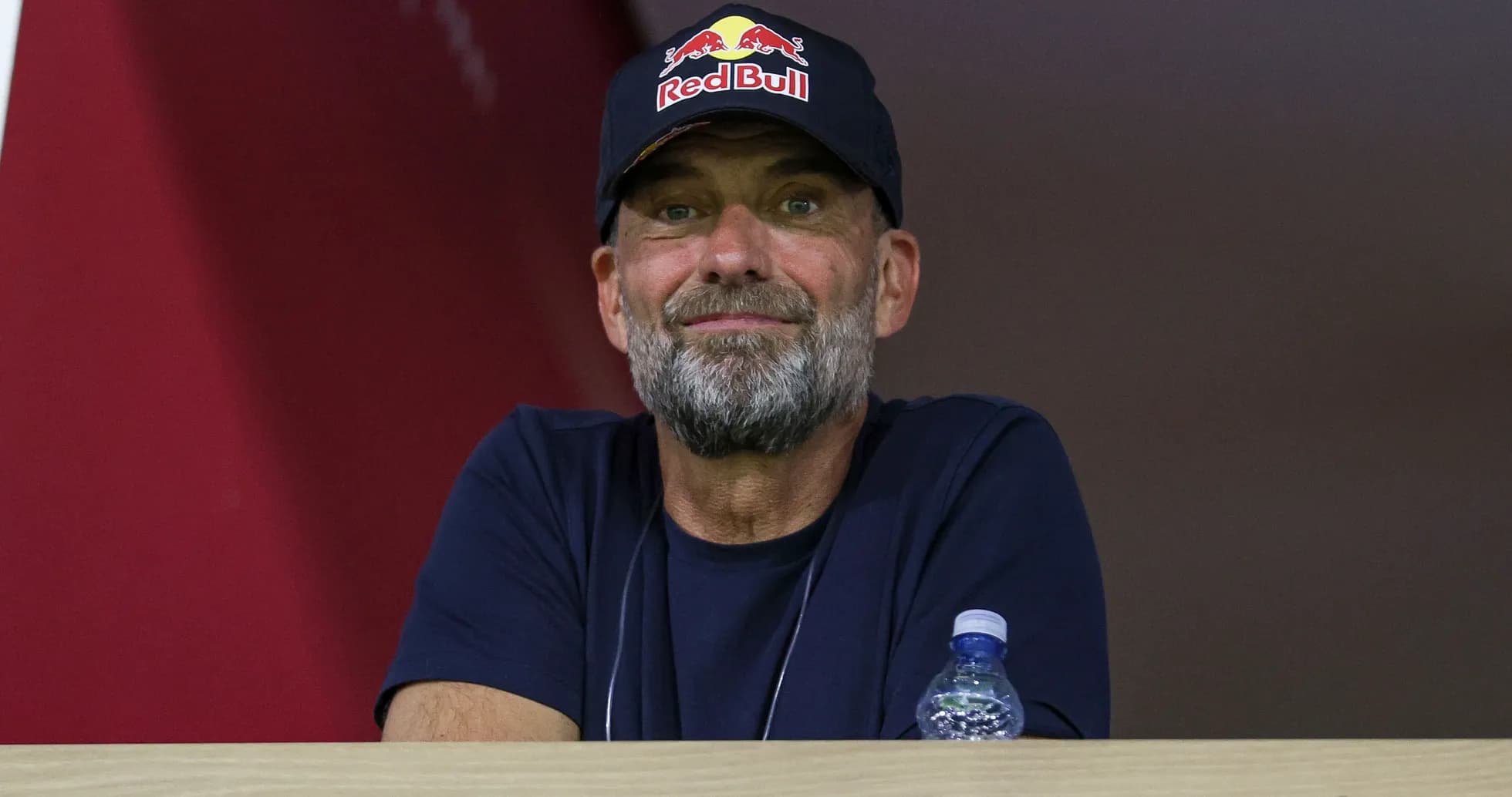 Человек в кепке Red Bull на трибуне