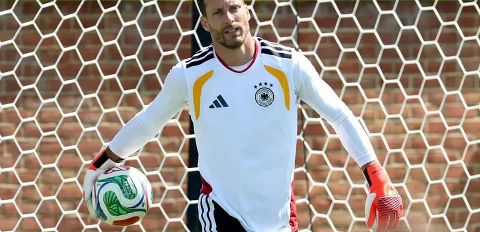Вратарь Германии держит мяч на тренировке