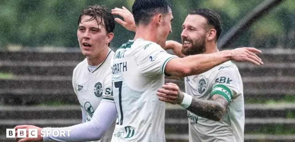 Игроки Hibernian празднуют гол под дождем