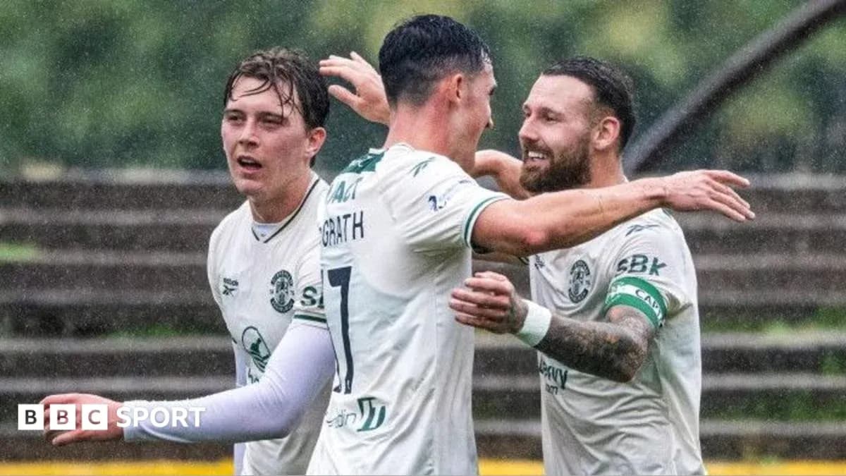 Игроки Hibernian празднуют гол под дождем