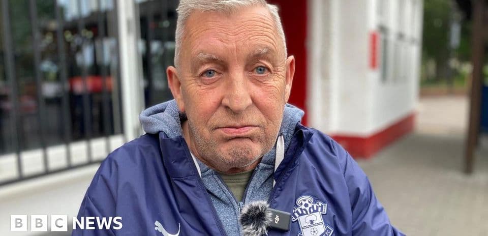 Пожилой мужчина в куртке Southampton FC на улице