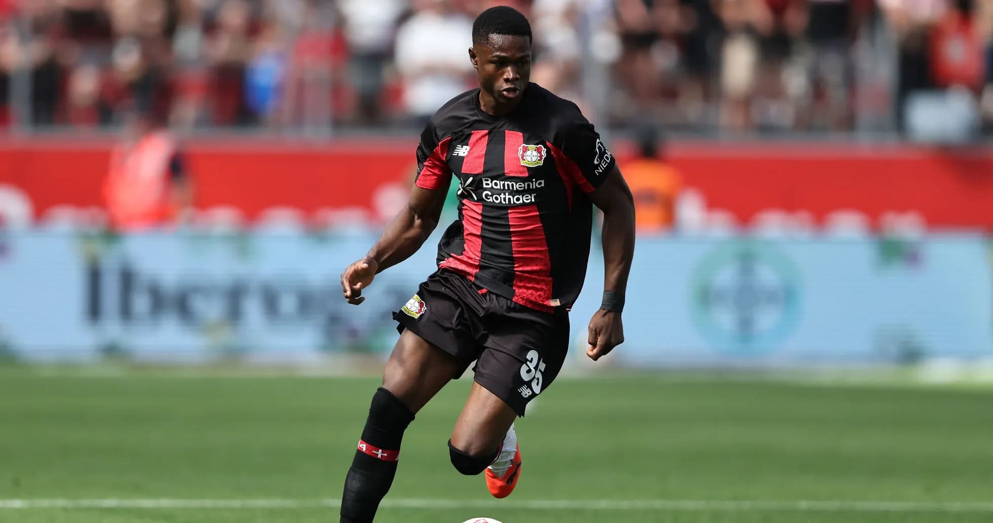 Игрок Bayer 04 Leverkusen с мячом на поле