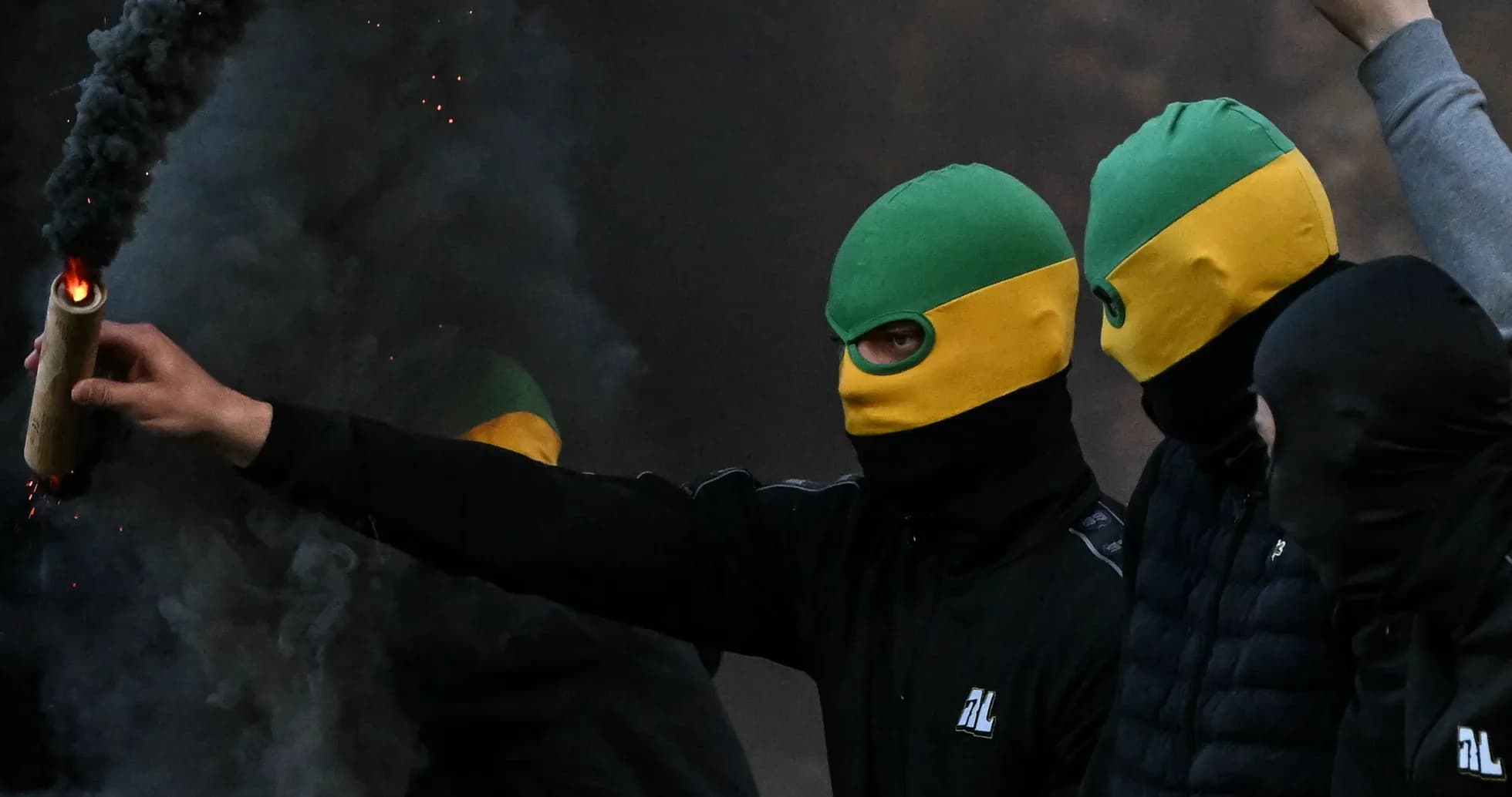 Группа людей с дымовыми шашками на фоне дыма Группа людей с дымовыми шашками на фоне дыма