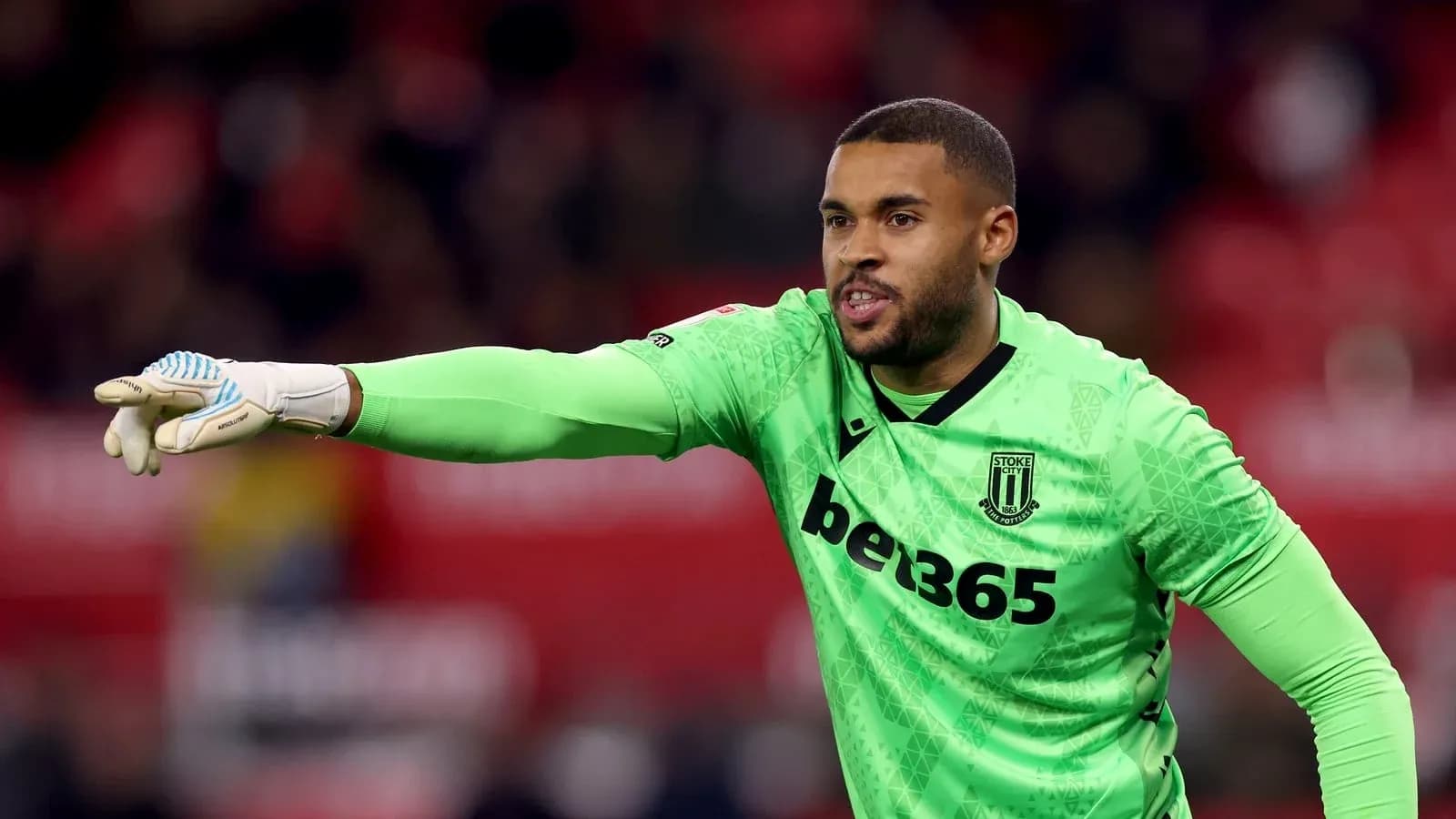 Вратарь команды Stoke City подает команды на поле Вратарь команды Stoke City подает команды на поле