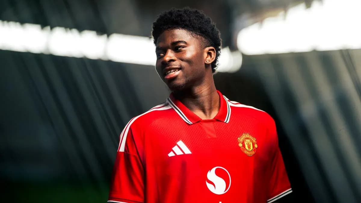 Игрок в красной футболке Manchester United улыбается Игрок в красной футболке Manchester United улыбается