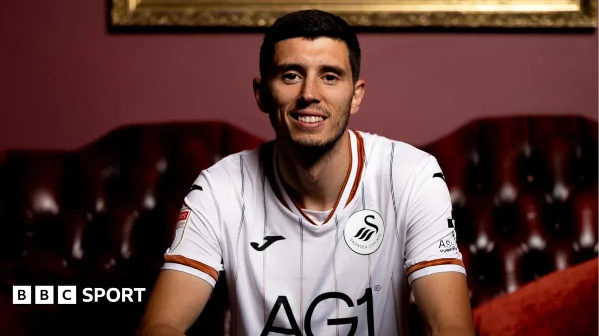 Игрок в футболке Swansea City сидит на диване Игрок в футболке Swansea City сидит на диване