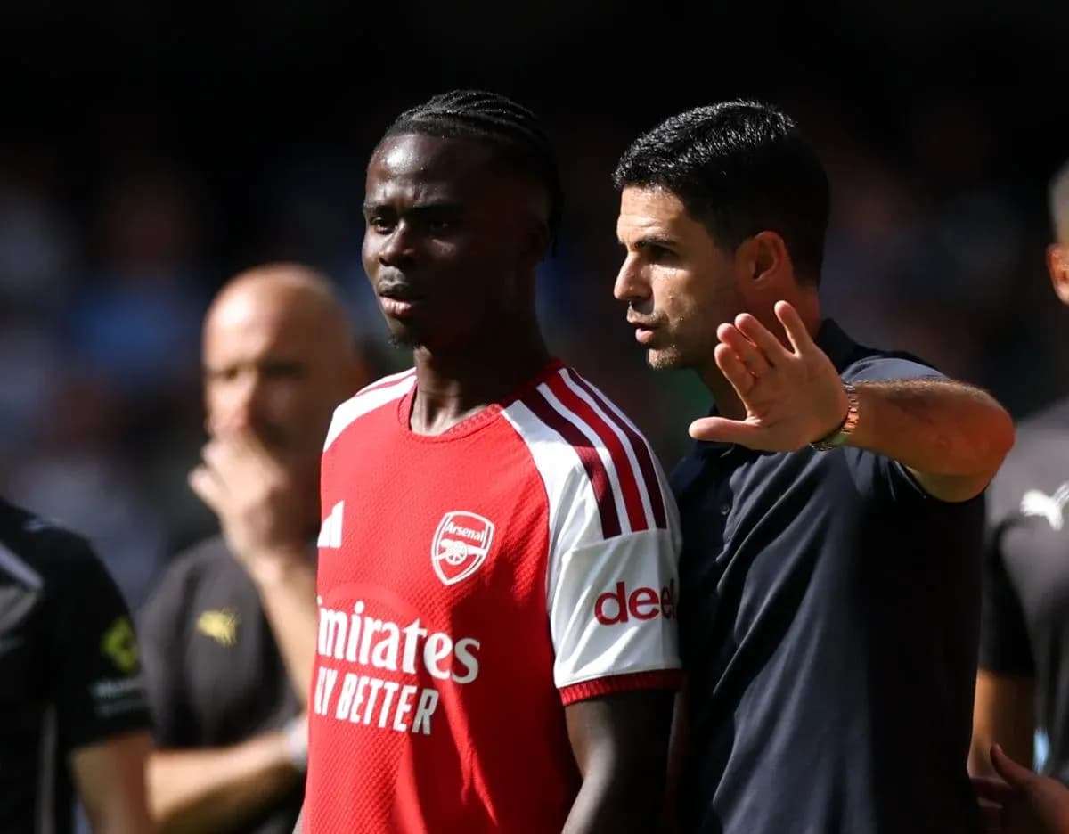 Тренер объясняет тактику игроку Arsenal на поле Тренер объясняет тактику игроку Arsenal на поле