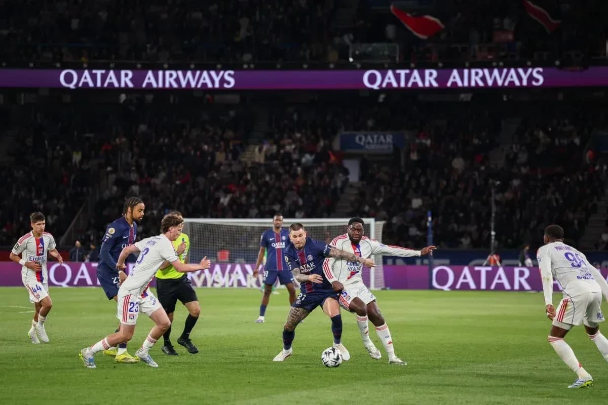 Игроки PSG и Lyon борются за мяч на поле Игроки PSG и Lyon борются за мяч на поле