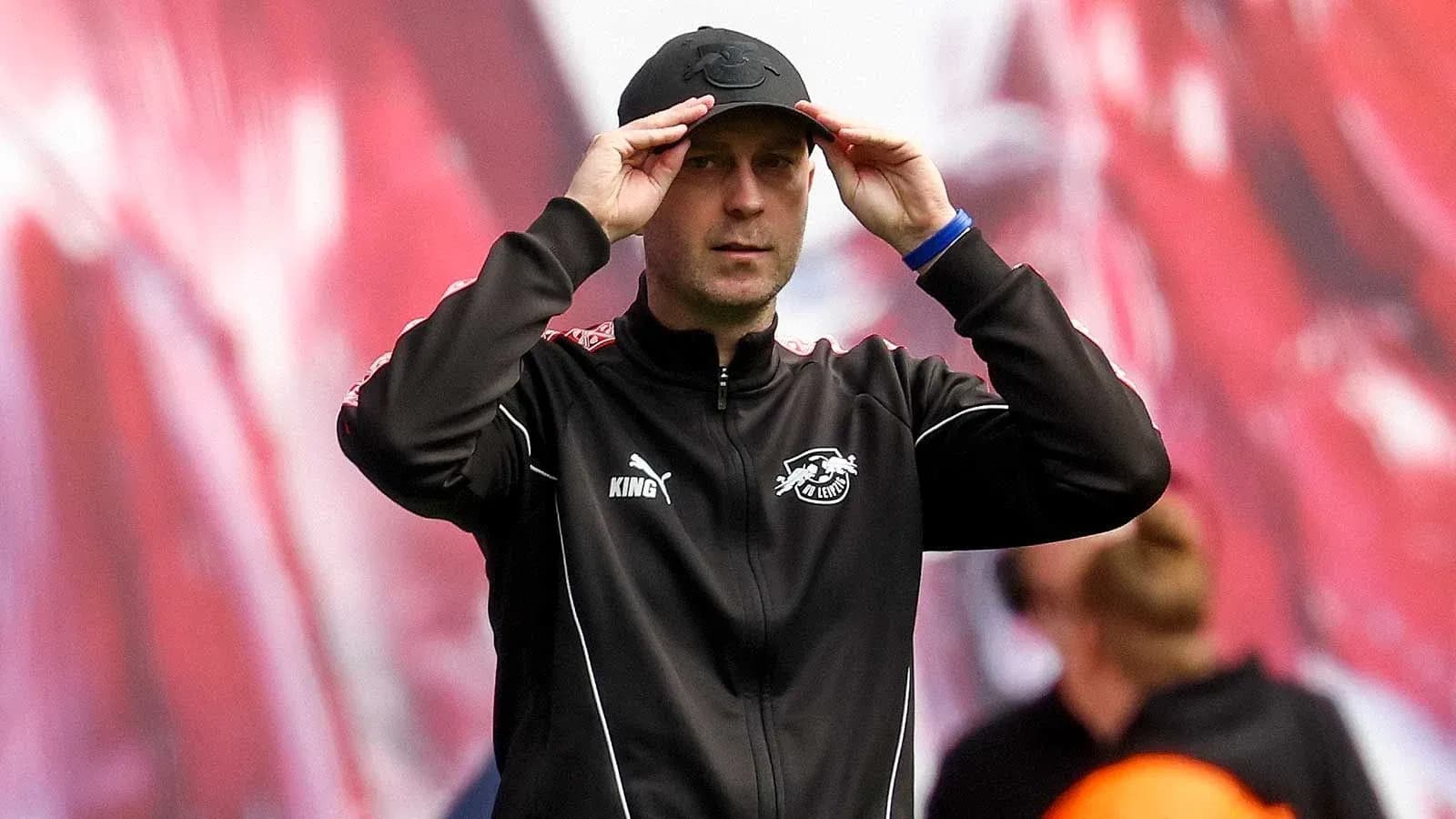 Тренер adjusts cap during match on the sideline Тренер adjusts cap during match on the sideline