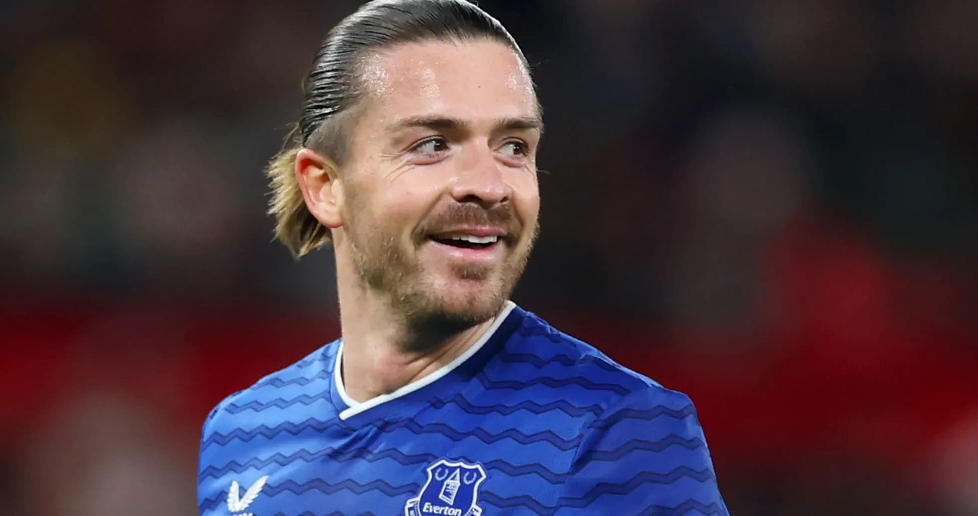 Игрок в синей форме Everton улыбается на поле Игрок в синей форме Everton улыбается на поле
