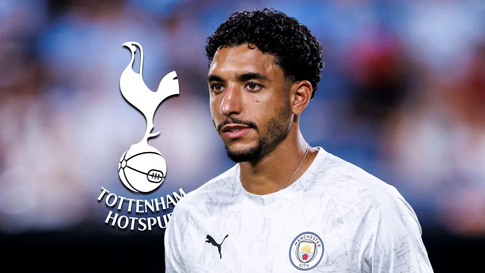 Игрок в футболке Manchester City на фоне логотипа Tottenham Игрок в футболке Manchester City на фоне логотипа Tottenham
