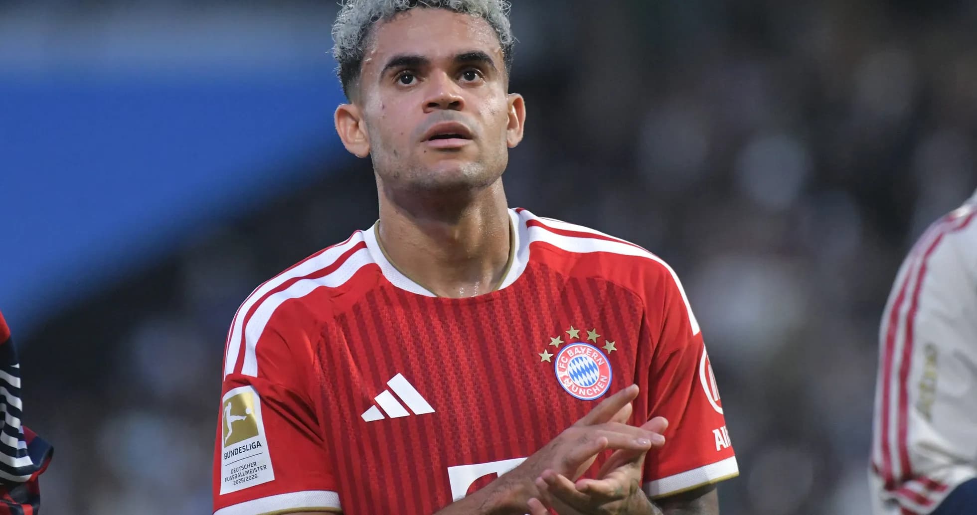 Игрок ФК Bayern München в красной форме на поле Игрок ФК Bayern München в красной форме на поле