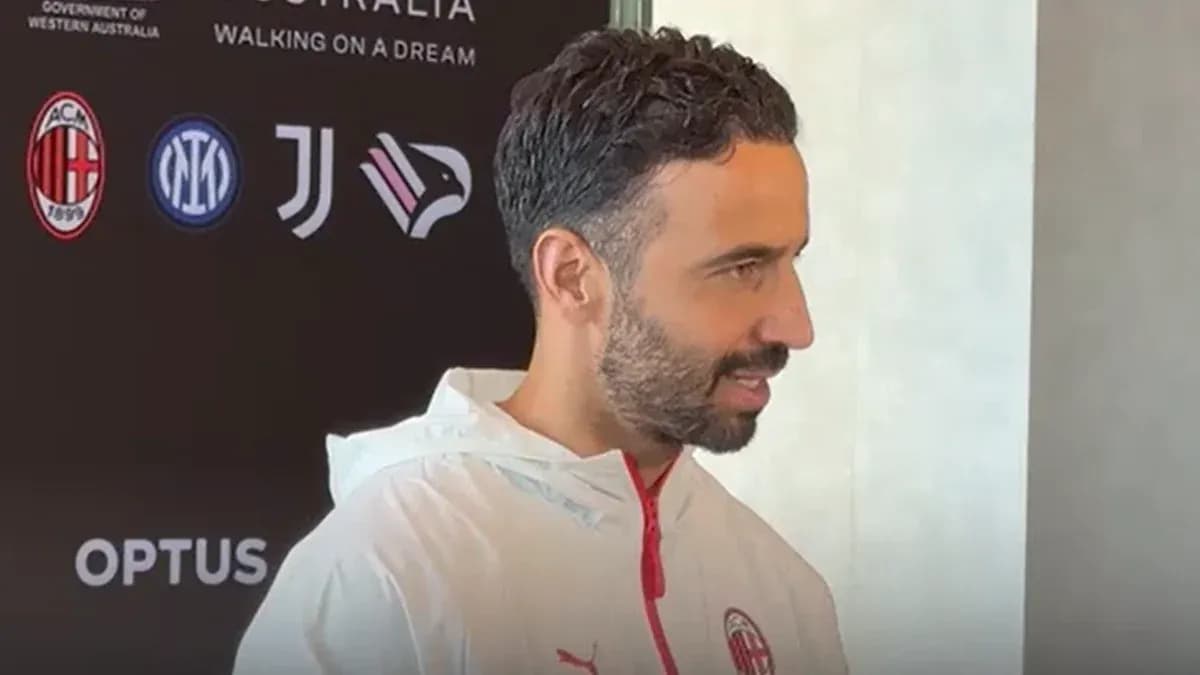 Человек в тренировочной куртке AC Milan на пресс-конференции Человек в тренировочной куртке AC Milan на пресс-конференции