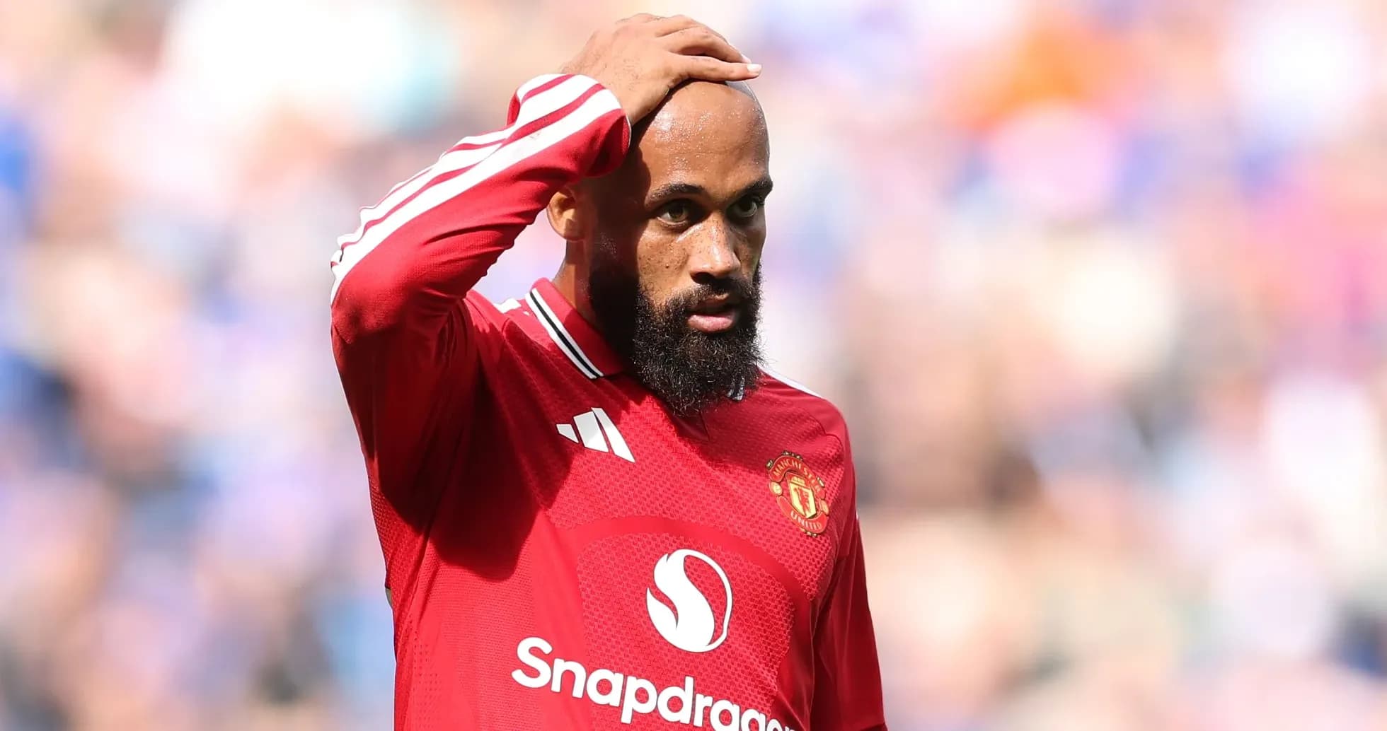 Игрок Manchester United с рукой на лбу во время матча Игрок Manchester United с рукой на лбу во время матча