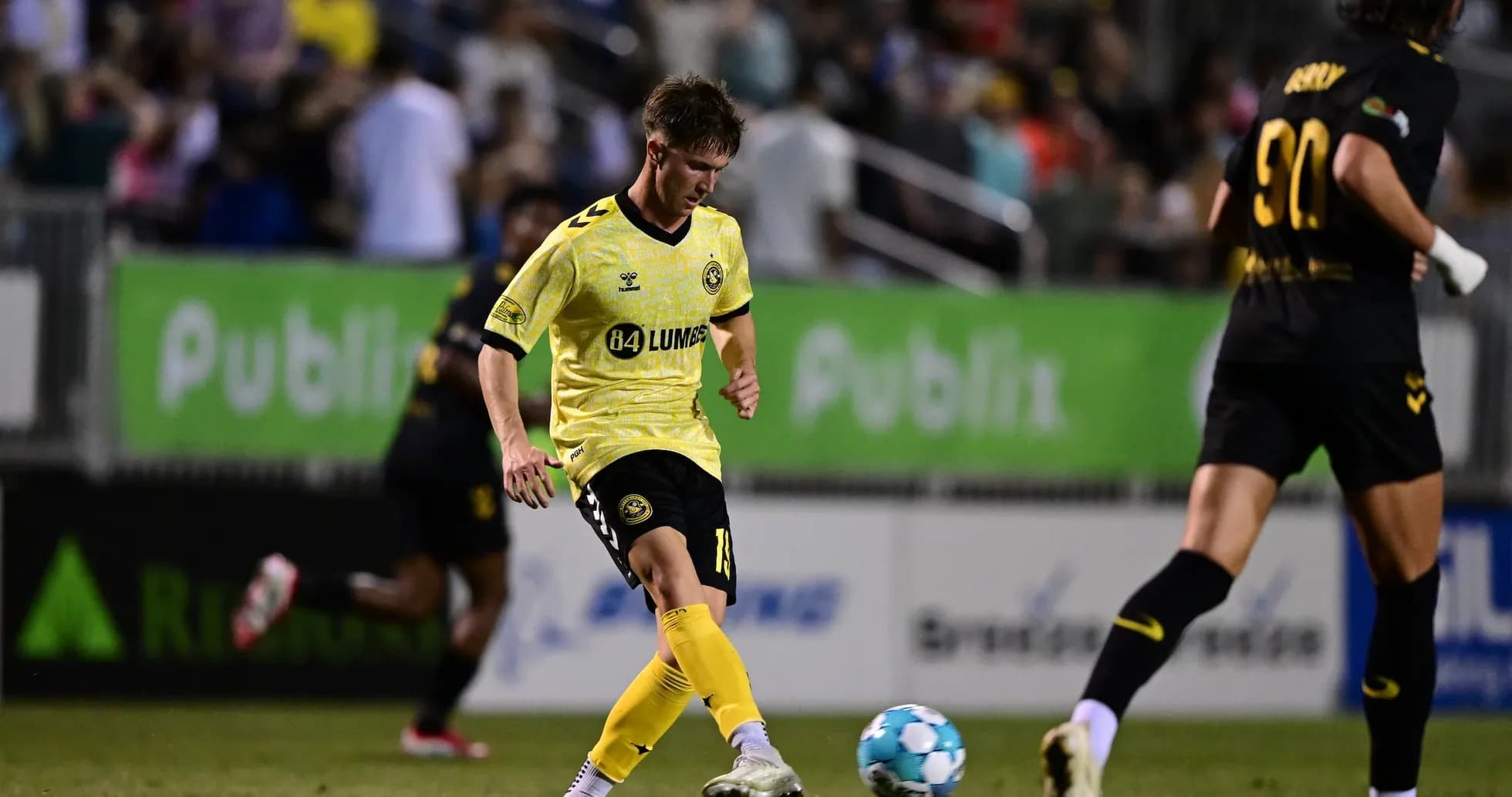Игрок Charleston Battery с мячом на поле Игрок Charleston Battery с мячом на поле