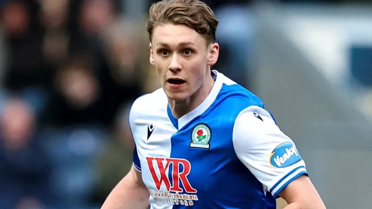 Игрок в форме Blackburn Rovers бежит по полю Игрок в форме Blackburn Rovers бежит по полю